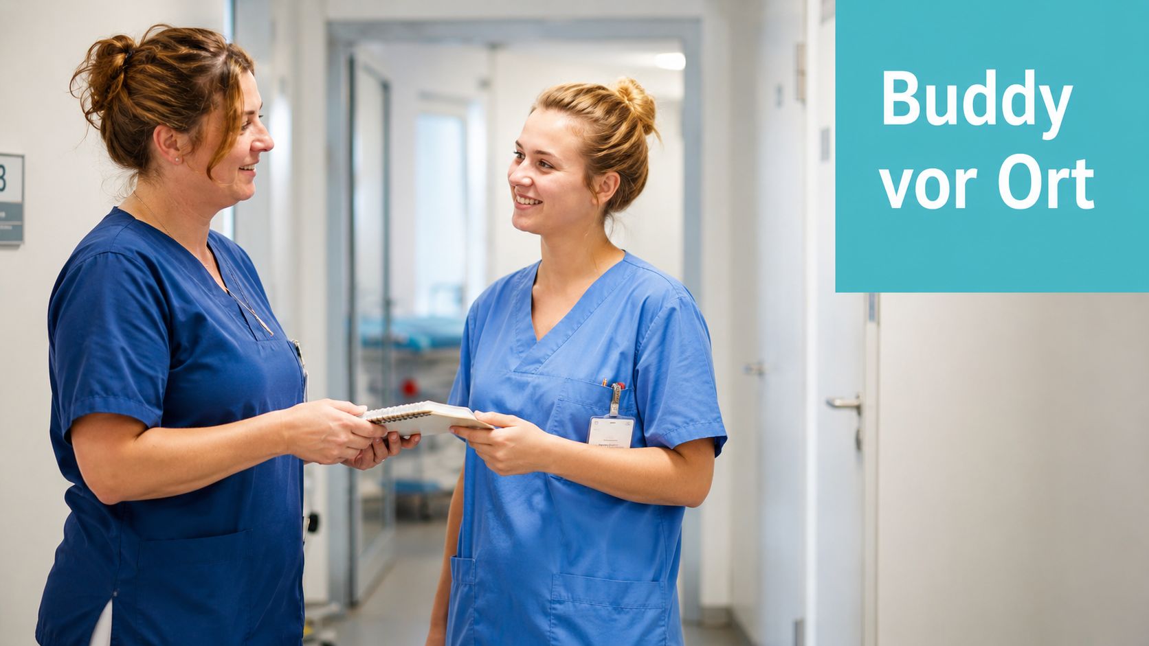 Zwei Pflegerinnen in blauer Arbeitskleidung unterhalten sich in einem Krankenhausflur und halten gemeinsam ein Notizbuch.